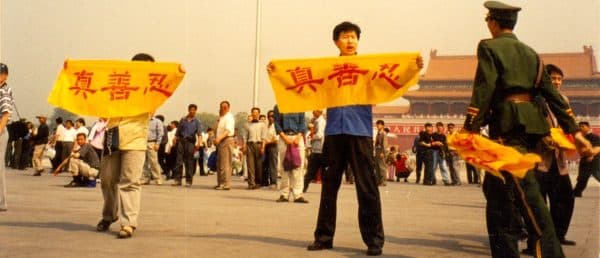 Para praktisi Falun Gong membentangkan spanduk bertuliskan karakter Mandarin: Sejati, Baik, Sabar, di Lapangan Tiananmen, Beijing.