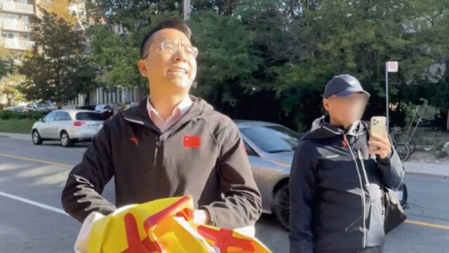 Seorang pria berbahasa Mandarin mengancam akan membunuh seorang praktisi Falun Gong di luar Konsulat Tiongkok di Toronto sambil merobek-robek spanduk milik praktisi tersebut. (Nora Geng)